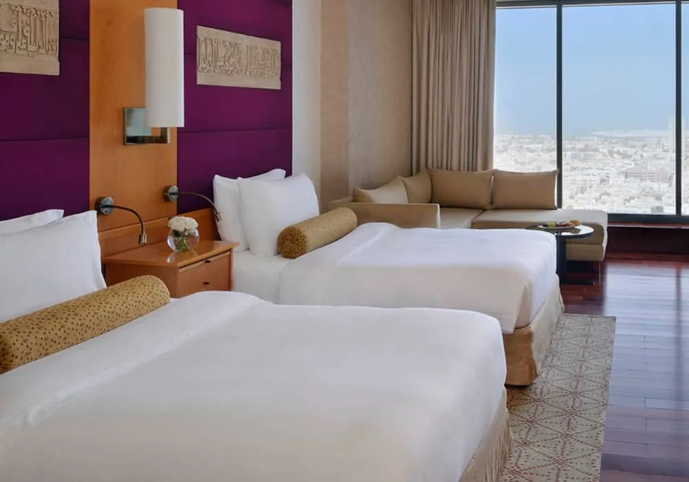 Deluxe bedroom in Dubai featuring two twin beds and a comfy sofa