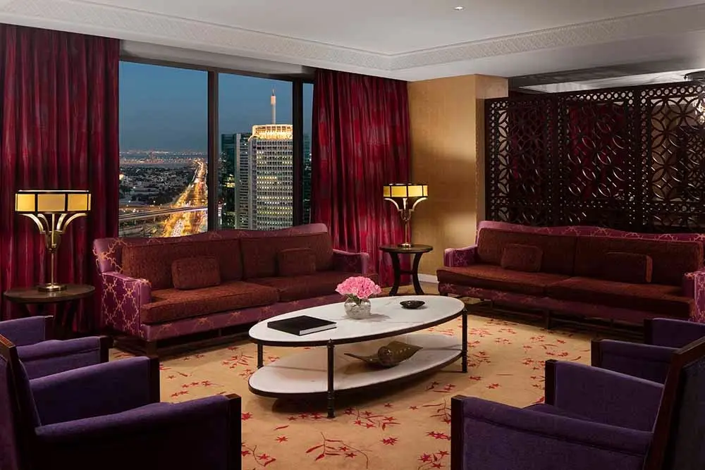 Luxury living room with comfortable seating and a window view of Dubai's glittering city at night