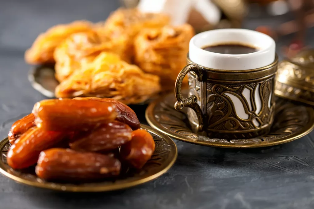 Dates and Arabian coffee served in an ornate cup